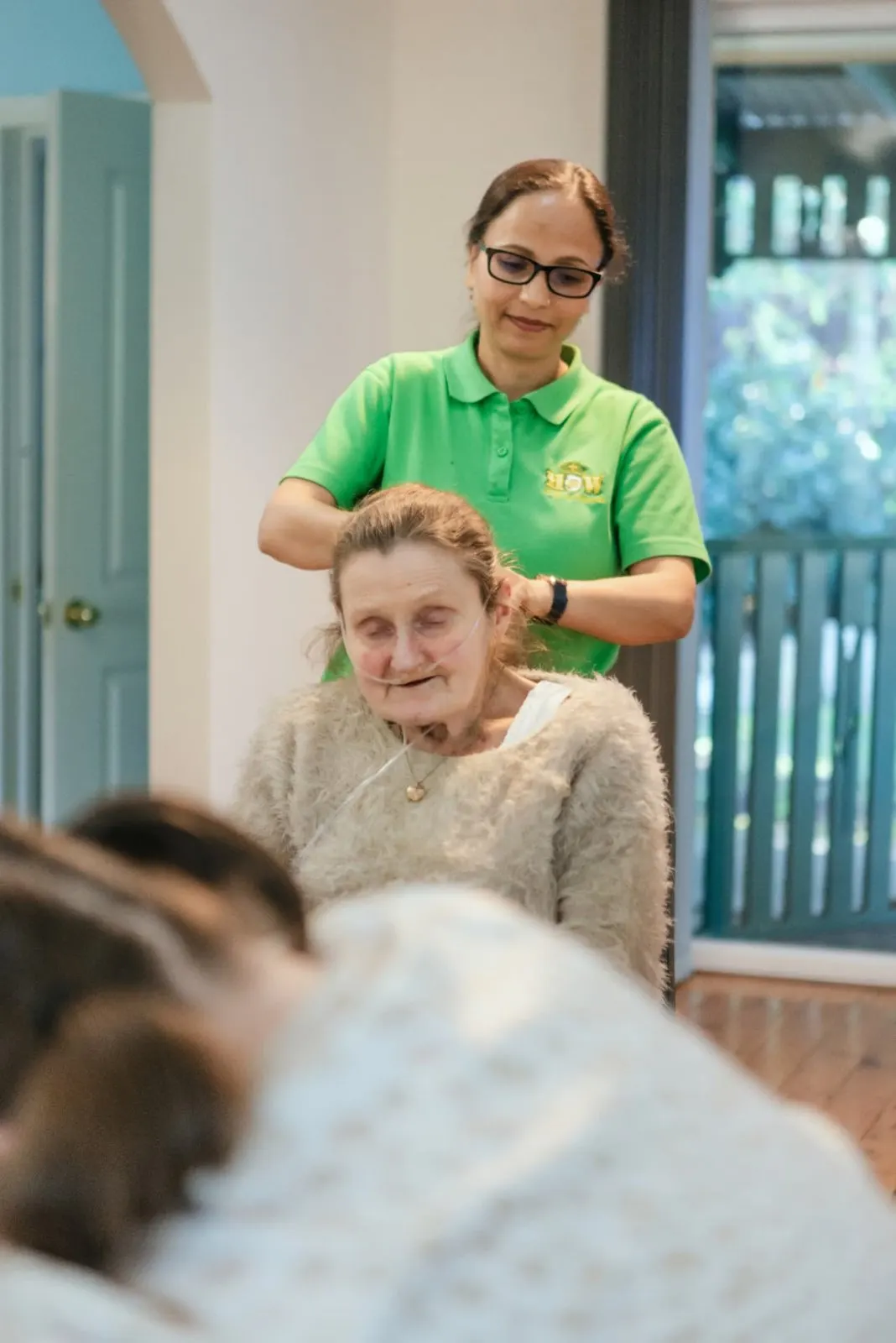 Support worker helping a participant with hair care at home