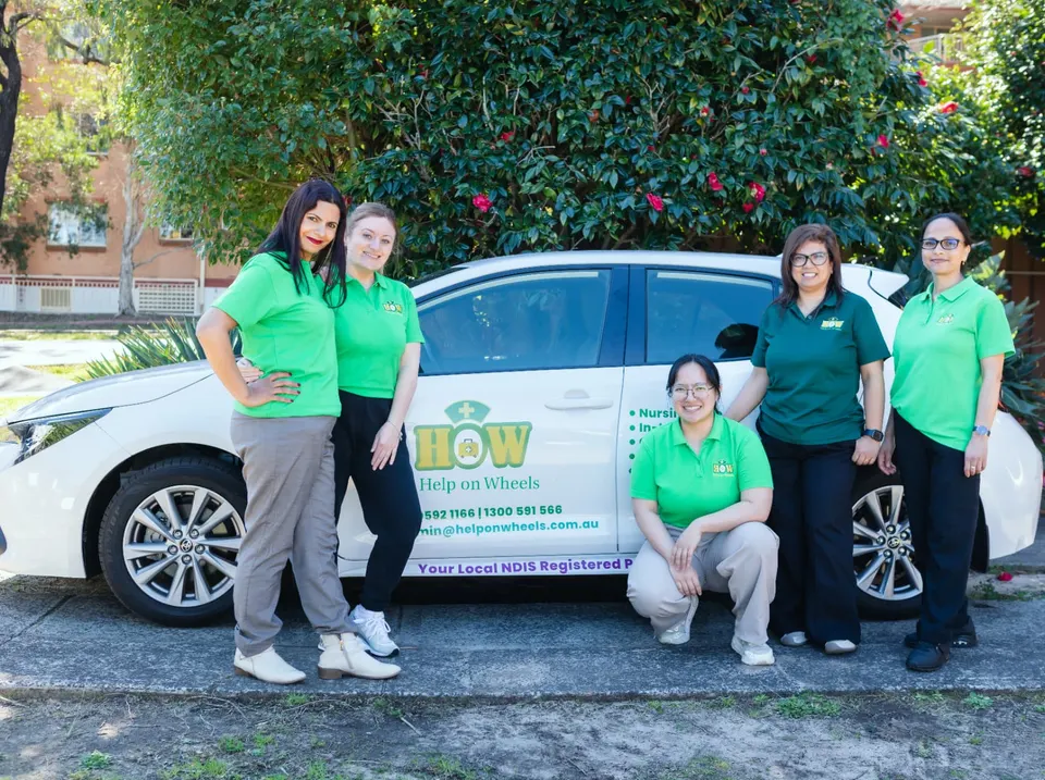 The Help on Wheels team together in front of their branded car before transport shifts